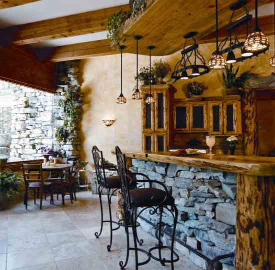 A view of Flathead Lake enlivens the spacious kitchen. A local Amish woodworker built the pine kitchen cabinets, and Mary stressed and finished them with natural-oil stains, then cut rusty metal panels to decorate their fronts. She carved birds and animals into scarred spots in the kitchen wood.